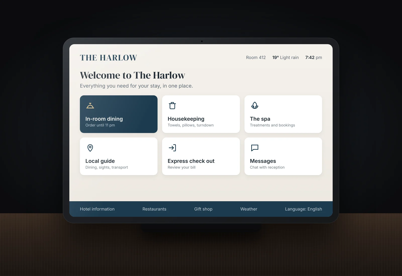 An illustrative off the shelf digital compendium for a fictional hotel, The Harlow: a tablet showing the hotel's name over a grid of tiles for in-room dining, housekeeping, the spa, local guide, check out and messages.